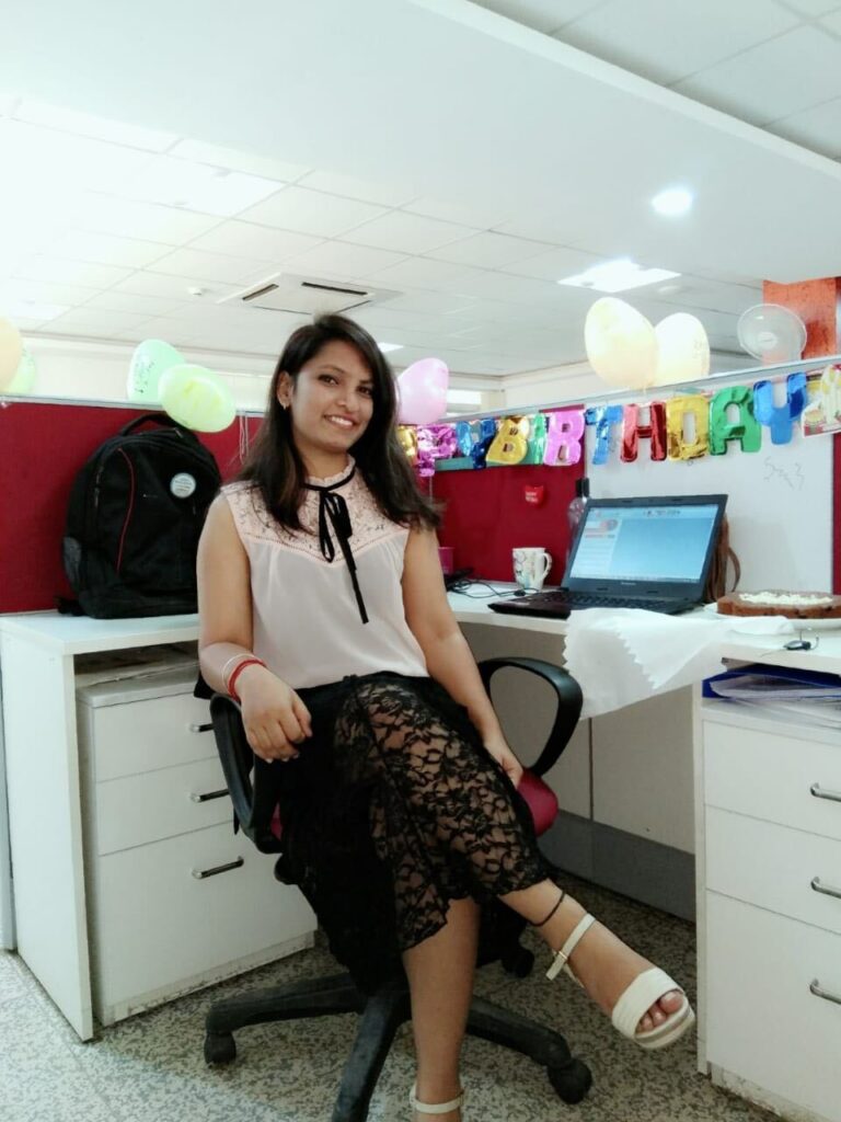 Young Indian woman smiling at her office desk during an early independent chapter of her life